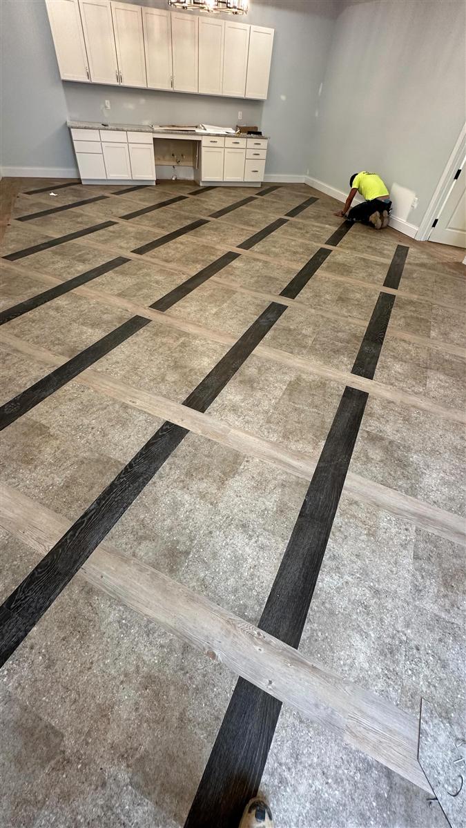 Custom two-tone plank grid being glued down by an MB3 installer